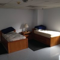Bunk room with two twin beds and a nightstand with a lamp between them