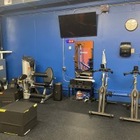The station fitness room, equipped with strength machines and cardio equipment for members.