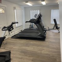 Treadmill and cardio machines in the fitness room, open to members around their schedules.