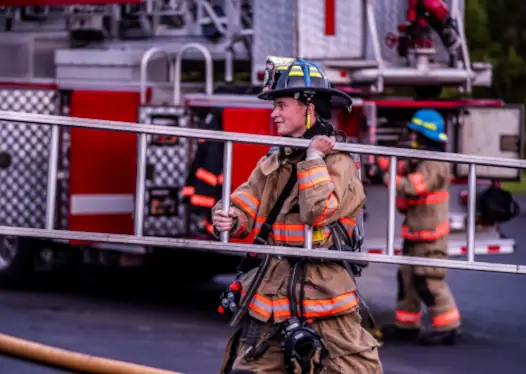 Firefighter carrying a ladder