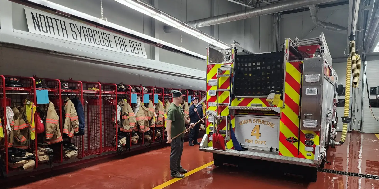 Firefighter washing engine in fire station